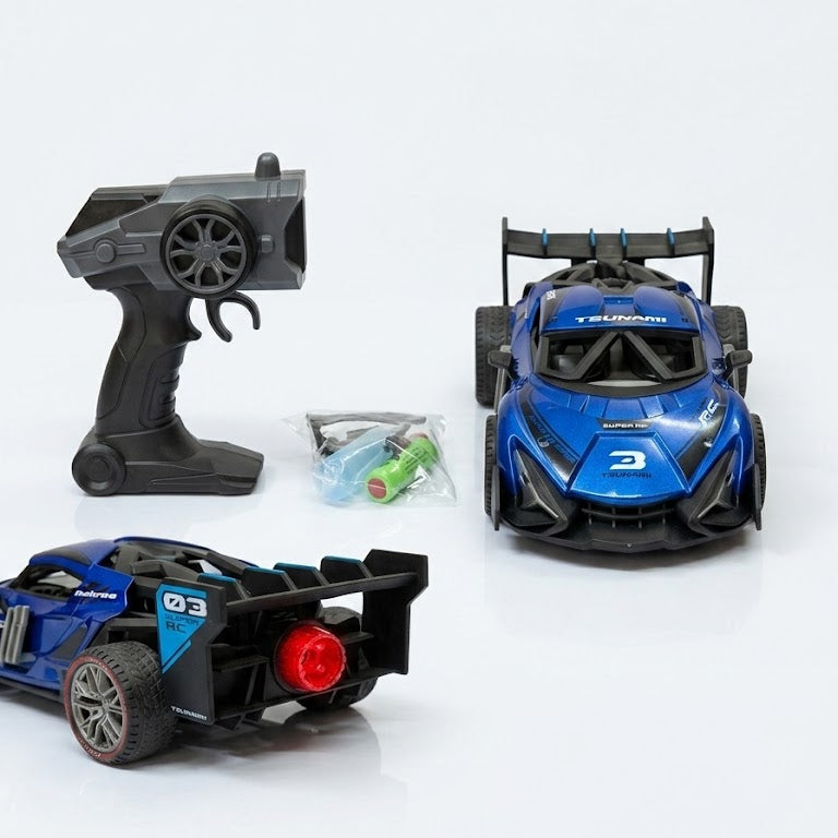 A blue remote control race car set with a black remote controller, a small plastic bag of green battery batteries, and a second view of the blue race car on a clean white background.